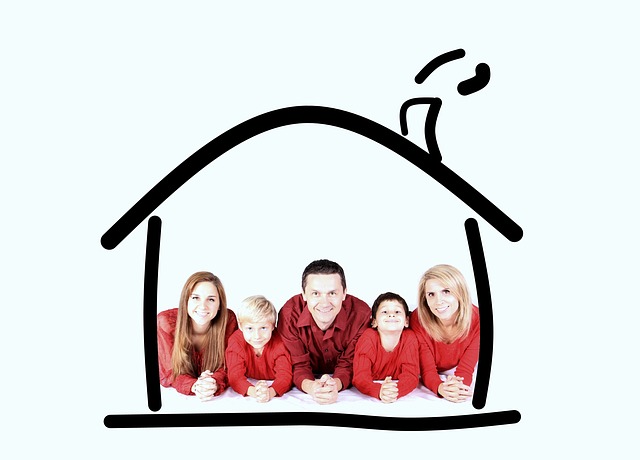 rodina v červeném oblečení pod načrtnutým domkem